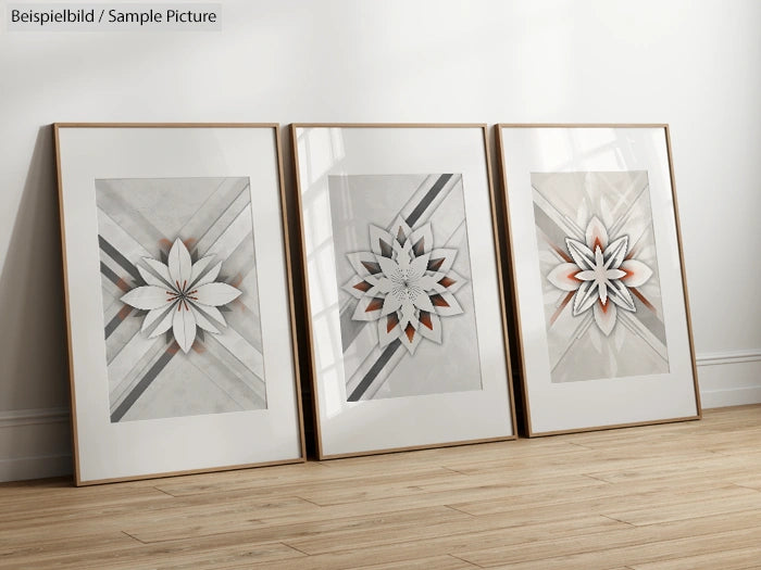 Three framed geometric floral art prints on a wooden floor against a white wall.