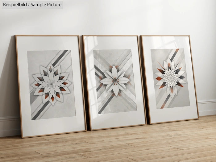 Three framed geometric flower artworks on a wooden floor against a white wall.